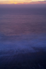 The sun dips below the skyline painting a pastel palette over the Pacific Ocean.