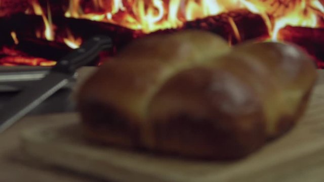 Brazilian Homemade bread on top of a wooden countertop in front of fire in 4k. Copy Space. 