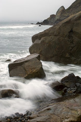 Fototapeta na wymiar Waves crash along the rocky shoreline on Steep Ravine Beach in Mount Tamalpais, CA