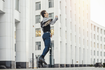 Distant plan of happy man going to or from work and dancing.