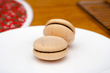 Obraz na płótnie Canvas Macarons with chocolate filling on a white plate with a red and white placemat