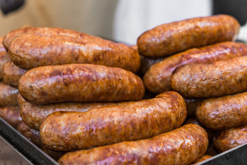 Grilled barbecue chorizo meat sausages, Argentina traditional staple food plate, at a street food market