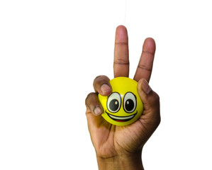 One hand holding a smiling emoji ball in victory sign