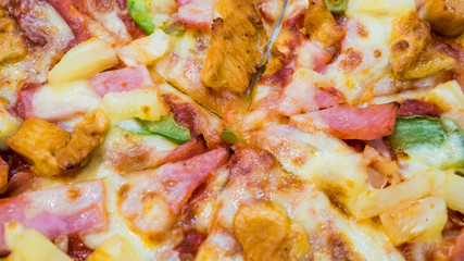 Pizza with ham, cheese and mushrooms, chicken,tomatoes,pine apple, Italian cuisine close up