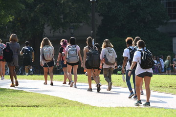 A group of female students walk across the campus of UNC Chapel Hill
