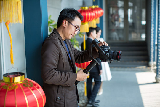 Photographer and video maker man hold DSLR camera on his hand to making footage. video production artist concept. image for objects, article, copy space and illustration.