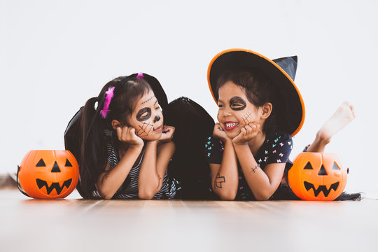 Happy Asian Little Child Girl In Costumes And Makeup Having Fun On Halloween Celebration