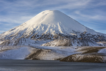 Parinacota Volcano above the horizon over Chungara lake waters an awesome and dramatic cloudy landscape inside Lauca National Park. A panoramic view of the chilean "altiplano" inside the Andes, Chile