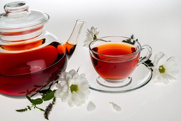 Clear teapot and teacup with flowers