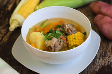 Traditional Chilean Cazuela de Vacuno or Carne beef soup with potato, corn, pumpkin, carrot, bell pepper, onion and rice, coriande. Decorated with tomatos, potatoes and fresh corn. 