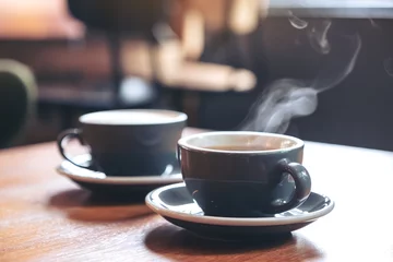  Close-up beeld van twee blauwe kopjes hete latte koffie en Americano koffie op vintage houten tafel in café © Farknot Architect