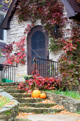 Naklejka premium Seasonal house outdoor decoration. Main entrance stair of the old style brick house decorated for autumn holidays season. Vertical composition.