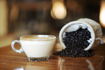 Cup of coffee with coffee bean on wooden table