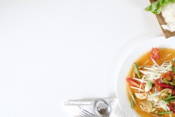 Som tam thai, green papaya salad on white table with space.