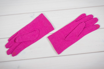 Pink gloves for woman on boards, clothing for autumn or winter concept