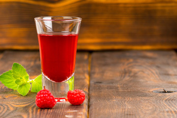 raspberry liqueur with mint on wooden table