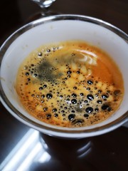 Close up bubbles of hot coffee in white ceramic cup
