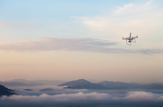 drone copter flying with digital camera.Drone with high resolution digital camera. Flying camera take a photo and video.The drone with professional camera takes pictures of the misty mountains.