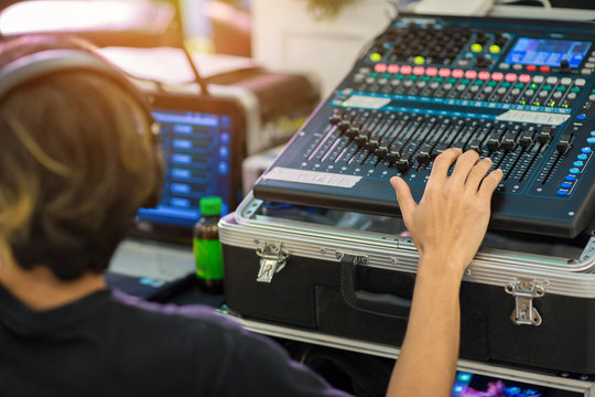 Blur Photo Hand adjusting audio mixer. sound engineer hands working on sound mixer in live concert. DJ controlled the sound system by mixer equalizer in concert or wedding hall.