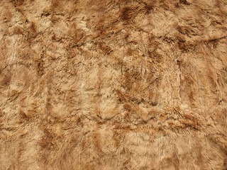 fragment of a fur carpet made of brown sheepskin.
