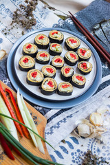 Vegan sushi rolls with chickpea hummus, cucumbers, nori seaweed, red bell pepper and avocado inside. Healthy vegetarian lunch or dinner with vegetables.