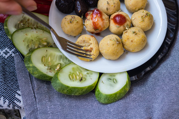 Woman hands take, hold duddha bowl with chickpea falafel balls, tomato sauce, olives, cucumbers, red pepper. Vegan vegetables lunch, vegetarian dinner, healthy dietary food
