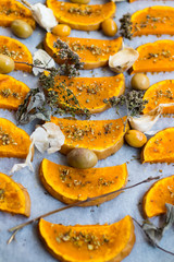 Sweet pumpkin slices grilled, roasted, backed on oven tray and parchment paper with oregano herbs, spices, garlic and olives. Vegan lunch, vegetarian vegetables dinner. Healthy organic food. 
