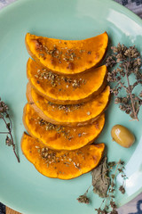 Sweet pumpkin slices on plate. Grilled, roasted, backed in oven with oregano herbs, spices, garlic and olives. Vegan lunch, vegetarian vegetables dinner. Healthy organic food. 