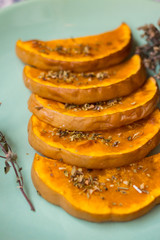 Sweet pumpkin slices on plate. Grilled, roasted, backed in oven with oregano herbs, spices, garlic and olives. Vegan lunch, vegetarian vegetables dinner. Healthy organic food. 