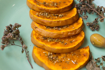 Sweet pumpkin slices on plate. Grilled, roasted, backed in oven with oregano herbs, spices, garlic and olives. Vegan lunch, vegetarian vegetables dinner. Healthy organic food. 