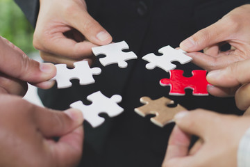 Hands of diverse people connecting puzzle together,  team engaging in finding best business solutions for successful teamwork, teambuilding unity concept.