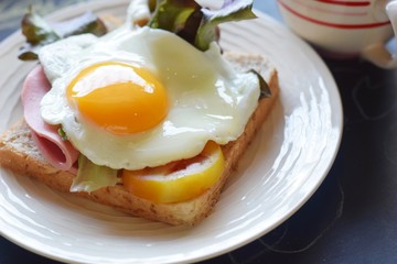 sandwich runny sunny side up egg ham with black coffee and glasses on blackboard background, brain boost breakfast concept