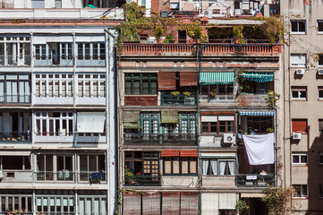 Exterior of houses with hanging clothes and colourful awnings in Barcelona