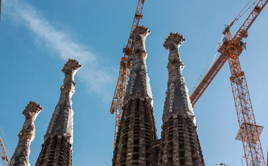 Exterior of unfinished Sagrada Familia with cranes in Barcelona