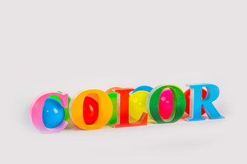 Colorful letters of the word color and colorful ball on the white background.