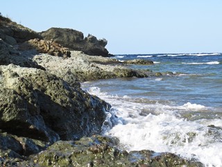 Fototapeta na wymiar View at Sea Ocean with Big Waves Hitting on Rock Coastline Shore
