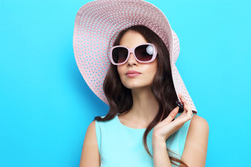 Fashion portrait of young woman wearing hat and sunglasses.