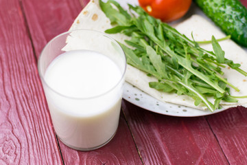 A glass of yogurt (kefir) and fresh vegetables. The concept of diet and healthy eating.