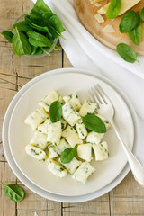 Homemade gnocchi with ricotta, cheese and spinach on a light plate.