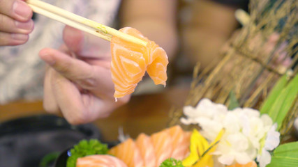 Chopstick Bowl of raw slice salmon sashimi in japanese restaurant