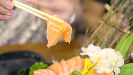 Chopstick Bowl of raw slice salmon sashimi in japanese restaurant