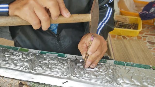 The craftsman use a hammer and nails, carved mineral.
