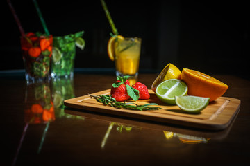 Fresh cocktail on a black background. Alcoholic cocktail on a black background. Fruit with a cocktail. Non-alcoholic cocktail. Mix of cocktails on a black background. 