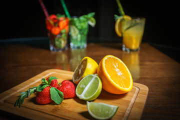Fresh cocktail on a black background. Alcoholic cocktail on a black background. Fruit with a cocktail. Non-alcoholic cocktail. Mix of cocktails on a black background. 