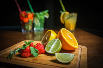 Fresh cocktail on a black background. Alcoholic cocktail on a black background. Fruit with a cocktail. Non-alcoholic cocktail. Mix of cocktails on a black background. 