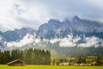Grainau, Germany with the cloudy Alps mountains in the background at summer sunlight