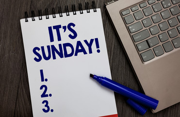 Handwriting text It s is Sunday. Concept meaning Day of rest and religious worship Part of the weekend Open notebook white page black marker computer keyboard wooden background