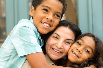 Happy Hispnaic mother laughing and talking with her children.