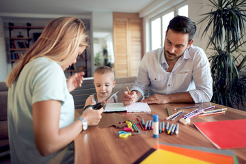 Mom ,dad and son draw in the living room