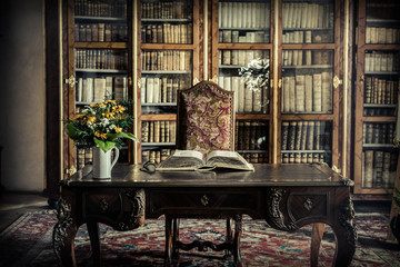 Fototapeta old library office with a book and a buqet of flowers obraz